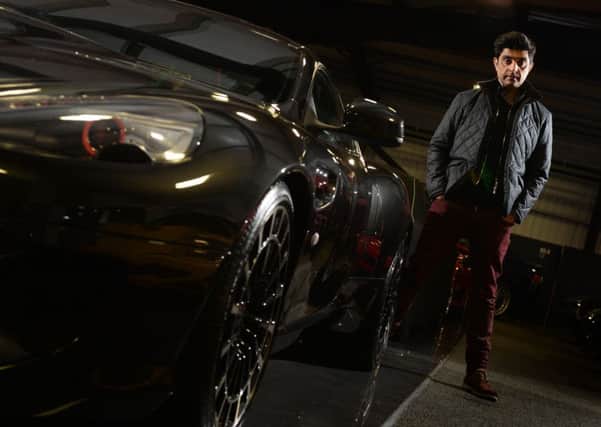 Top gear: Afzal Kahn at the Kahn Design showroom in Bradford stood next to an Aston Martin that his firm designed.  Picture: bruce rollinson