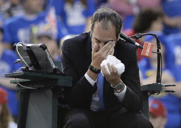 Umpire Arnaud Gabas, of France, holds his face after being hit by a ball hit in anger by Canada's Denis Shapovalov (Picture: Justin Tang/The Canadian Press via AP).