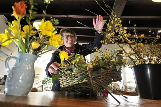 Jill Smith working on her flowers in her farm kitchen.