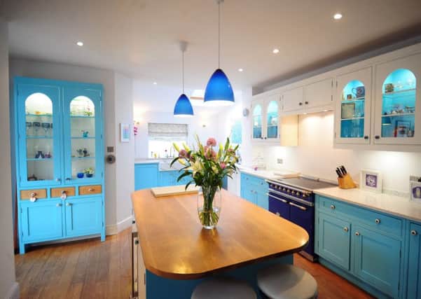 The kitchen with handcrafted cabinets and white worktops embedded with coloured glass