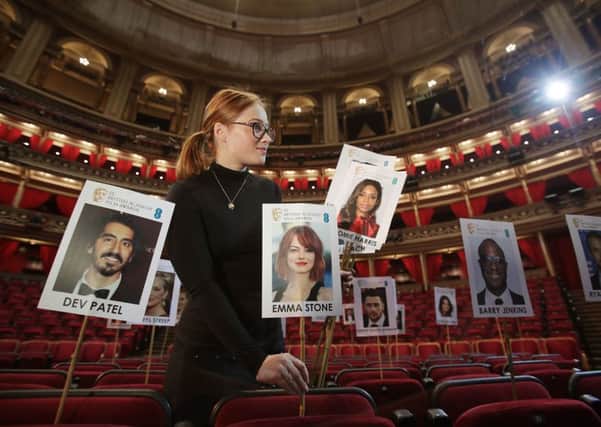 Georgie Cox places "heads on sticks" to check for camera blocking for the BAFTA Film Awards at the Royal Albert Hall