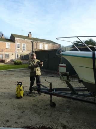Stewart Calligan, sporting different headgear, cleans his boat in readiness for an Easter launching.