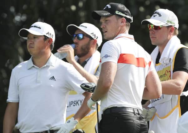 Danny Willett, second right, and David Lipsky, left, wait at the third