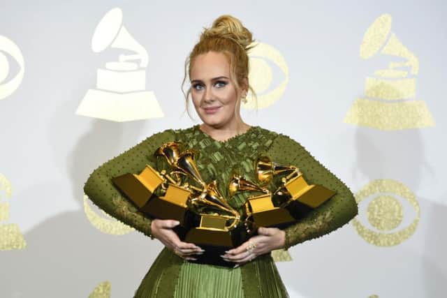 Adele poses in the press room with her five Grammy Awards.
