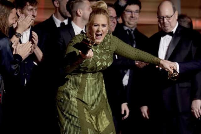 Adele accepts the award for album of the year for "25" at the 59th annual Grammy Awards.
