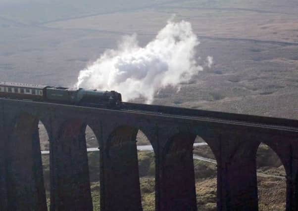 Tornado, the newest steam locomotive in Britain, pulls the first timetabled main line steam-hauled service for half a century across the Ribblehead viaduct in North Yorkshire.