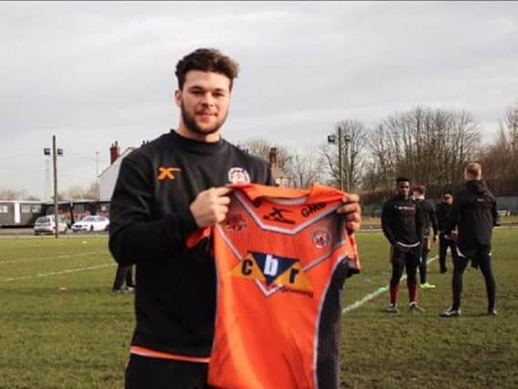 Alex Foster shows off a Castleford Tigers shirt at training