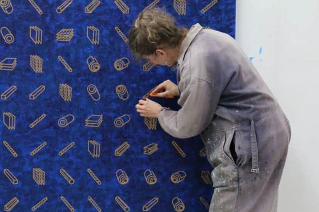 Vivienne Baker putting the final touches to one of the "clue" canvases