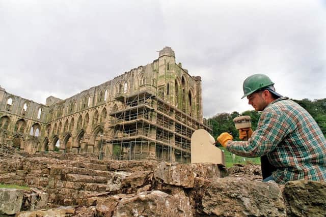 Banker mason Dave Patterson of Hull, putting his bankers mark on the last piece of stone of the conservation project at Rievaulx Abbey.