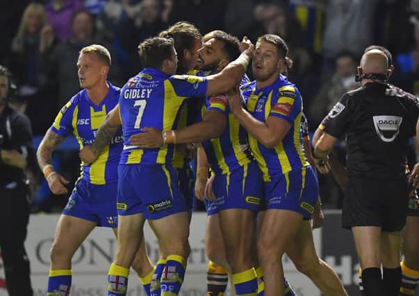 Warrington Wolves' Ryan Atkins  is congratulated after scoring his team's second try against Brisbane Broncos on Saturday night. Picture: Dave Howarth/PA.