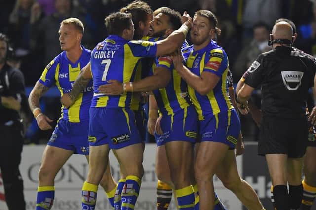 Warrington Wolves' players celebrate a try during their win over Brisbane Broncos on Saturday night. Picture: Dave Howarth/PA