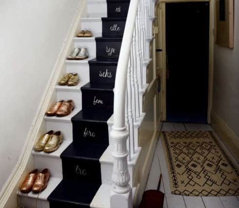 The stairs painted in black and white and numbered in Danish with Camilla's collection of glittery shoes as decoration