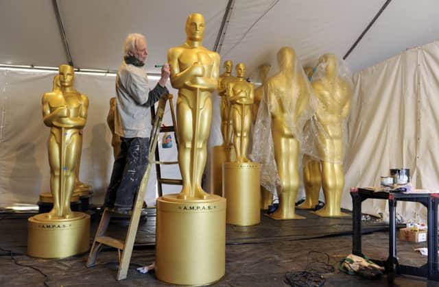 Scenic artist Sam Costa works on Oscar statues for Sunday's 89th Academy Awards