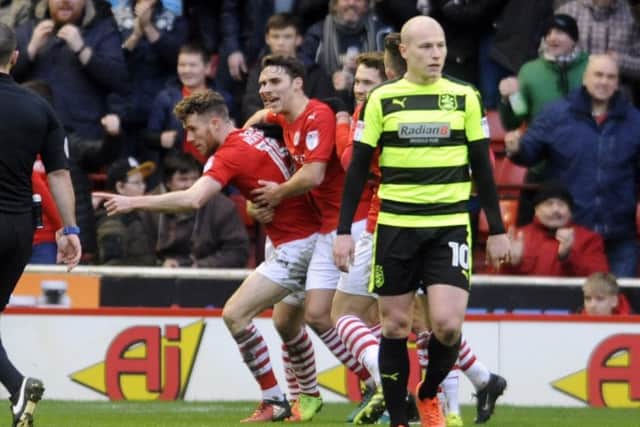 Barnsley striker Marley Watkins is mobbed as he celebrates scoring the equalising goal against Huddersfield Town (Picture: Simon Hulme).