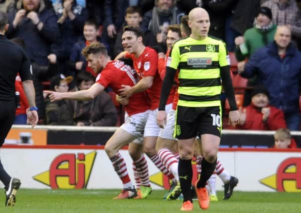 Barnsley striker Marley Watkins is mobbed as he celebrates scoring the equalising goal against Huddersfield Town (Picture: Simon Hulme).