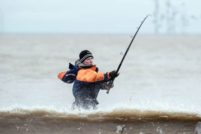 An angler competes in the world's largest beach angling festival on Tunstall Beach in Yorkshire.