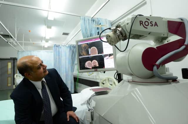 Consultant neurosurgeon Dev Bhattacharyya with the robot.