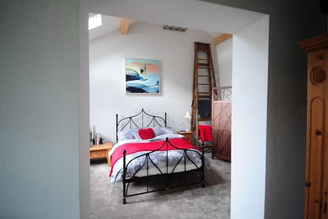 The bedroom in the new extension with vintage ladders and a painting by Patrick