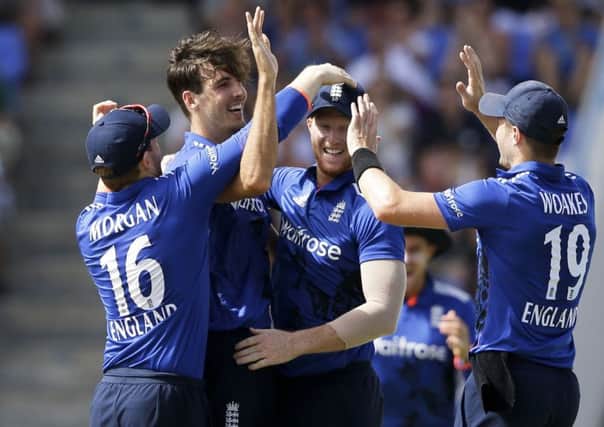 England's bowler Steven Finn, second from left, is greeted by teammates after he caught West Indies' Kieran Powell.