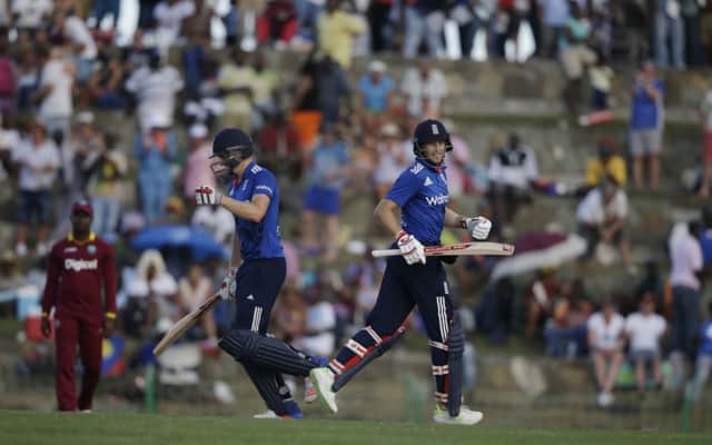 England's batsmen Chris Woakes, left, and Joe Root begin celebrating victory over the West Indies by four wickets in Antigua. Picture: AP/Ricardo Mazalan.