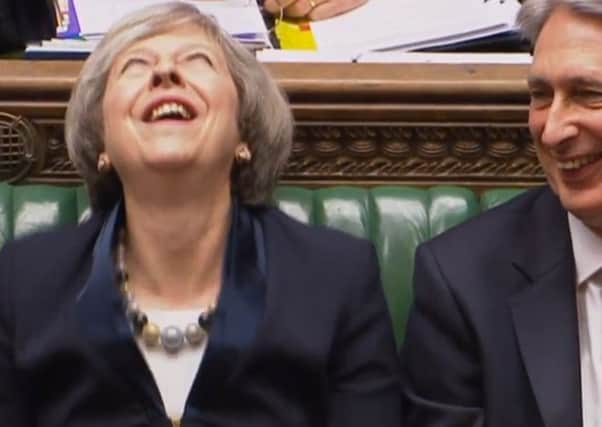 Theresa May laughing along with Chancellor Philip Hammond  during Prime Minister's Questions