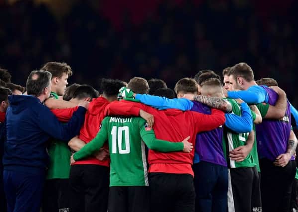 Lincoln City players huddle after the final whistle.