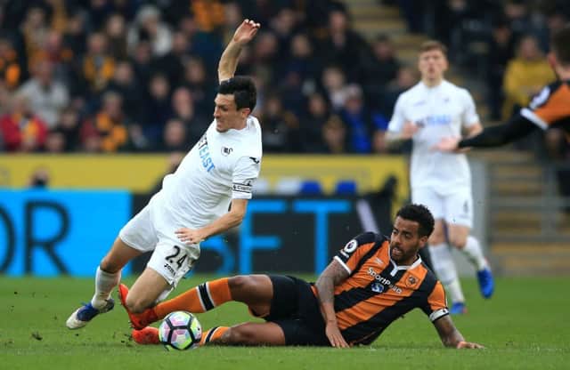 Swansea City's Jack Cork (left) and Hull City's Tom Huddlestone (right) battle for the ball. Picture: Nigel French/PA