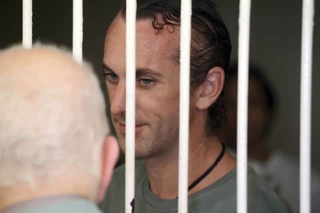 David Taylor, right, in a holding cell talks to his family before his verdict trial in Bali
