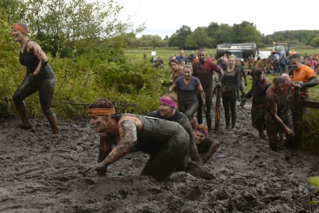 File photo dated 12/09/15 of participants crawling through thick mud during Tough Mudder