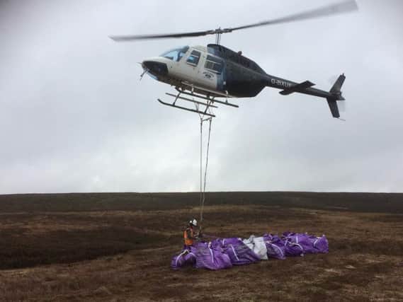 A helicopter is used to deliver large sandstone rocks to Colsterdale Moor near Masham.  Picture: Yorkshire Peat Partnership/Yorkshire Water.