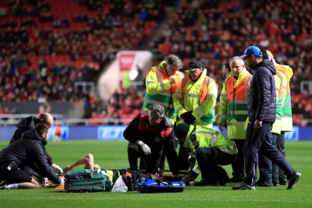 Huddersfield Town manager David Wagner checks on Jonathan Hogg as he receives treatment on the pitch. Picture: Adam Davy/PA .