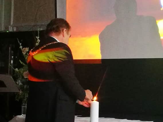 A candle is lit on Holocaust Memorial Day.