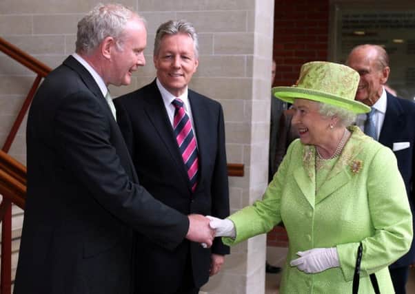 2012: The Queen shaking hands with Northern Ireland Deputy First Minister Martin McGuinness watched by First minister Peter Robinson (centre) at the Lyric Theatre in Belfast.