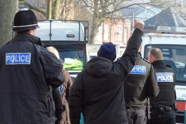Tree protesters are led away from felling in Chippinghouse Road by police.