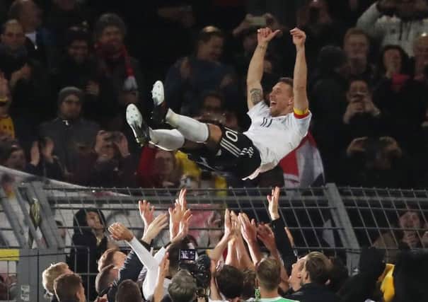 Germany's Lukas Podolski celebrates with team-mates after his final game.