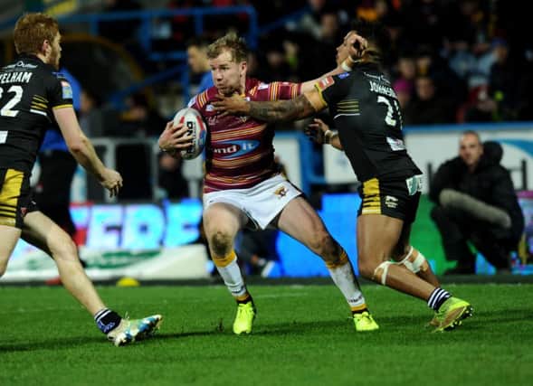 Huddersfield's Aaron Murphy is tackled by Salford's Gregory Johnson.
