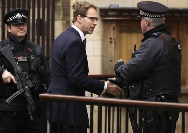 Conservative MP Tobias Ellwood shakes hands with an armed police officer as he arrives at the Houses of Parliament in London, Friday March 24, 2017. Ellwood desperately tried to save the life of Constable Keith Palmer, the police officer killed on Wednesday when a man went on a deadly rampage, first driving a car into pedestrians then stabbing a police officer to death before being fatally shot by police within Parliament's grounds in London.