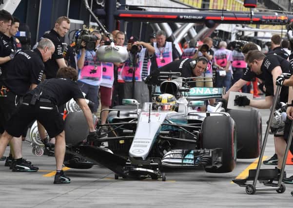 Britains Lewis Hamilton steers his Mercedes down the pit lane yesterday as he dominated the first practice session for the Australian Grand Prix in Melbourne (Picture: Andrew Brownbill/AP).