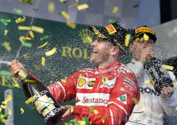 Ferrari driver Sebastian Vettel of Germany sprays champagne as confetti falls around him after winning the Australian Formula One Grand Prix in Melbourne, Australia. (AP Photo/Andy Brownbill)
