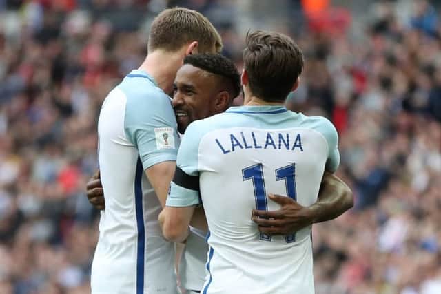 Eric Dier, left, and Adam Lallana congratulate Jermain Defoe after he had put England in front against Lithuania (Picture: PA).