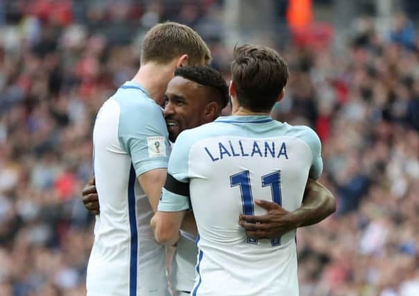 Eric Dier, left, and Adam Lallana congratulate Jermain Defoe after he had put England in front against Lithuania (Picture: PA).