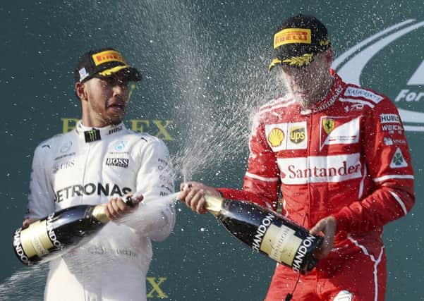 New rivalry? Ferrari driver Sebastian Vettel of Germany, right, and Mercedes driver Lewis Hamilton of Britain spray champagne at each other following the Australian Formula One Grand Prix in Melbourne, Australia. (AP Photo/Rick Rycroft)