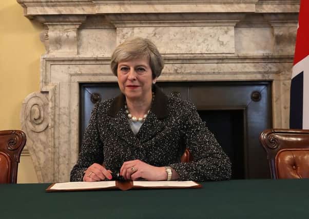 Theresa May signing the letter to confirm triggering Article 50