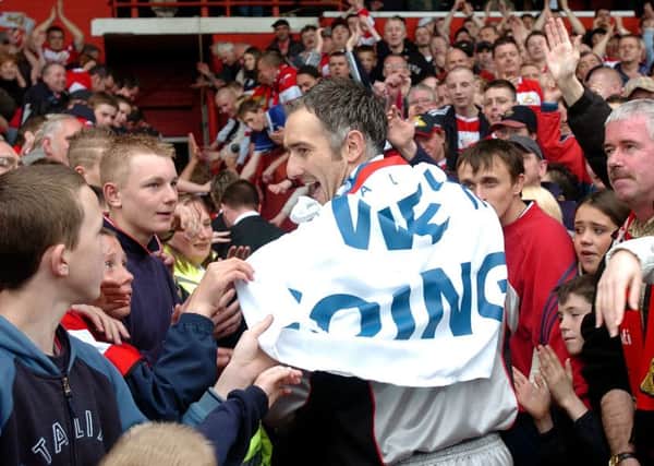 Doncaster Rovers fans surround the players tunnel as goal keeper Andy Warrington leaves the pitch after promotion in 2004.