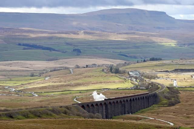 The Flying Scotsman crosses the Ribblehead viaduct in North Yorkshire, as the Settle-Carlisle railway line reopens after floods.
