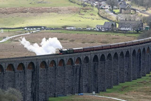 The Flying Scotsman crosses the Ribblehead viaduct in North Yorkshire, as the Settle-Carlisle railway line reopens after floods.