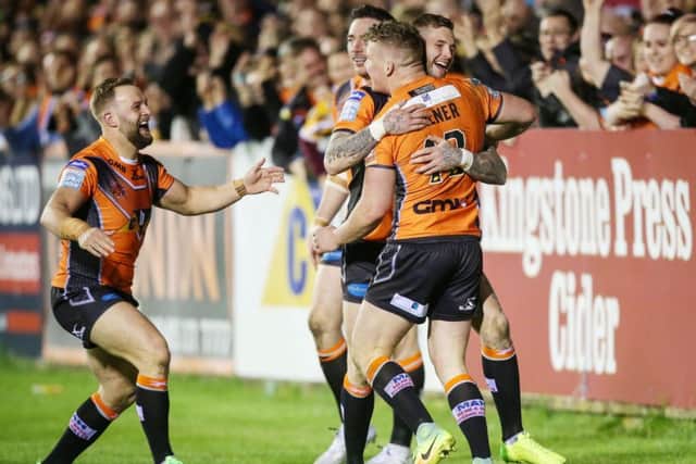Castleford Tigers' Adam Milner (right) celebrates scoring a try with his team-mates.