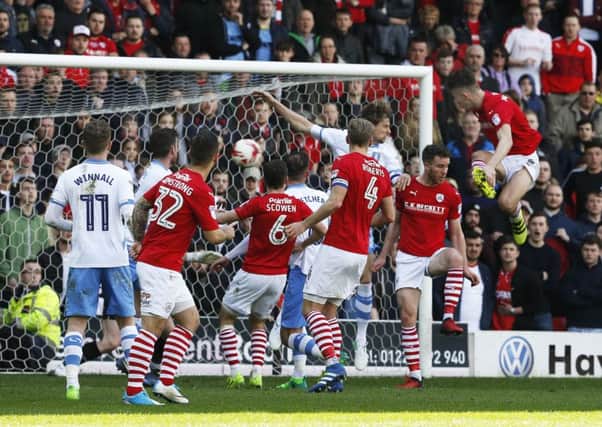 LATE ARRIVAL: Angus MacDonald rises highest to bring Barnsley level with Sheffield Wednesday at Oakwell on Saturday. Picture: Steve Ellis