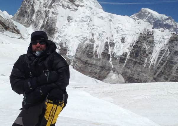 Leslie Binns pictured with Mount Everest in the background. He abandoned his attempt to reach the summit last year to help save a fellow climber.