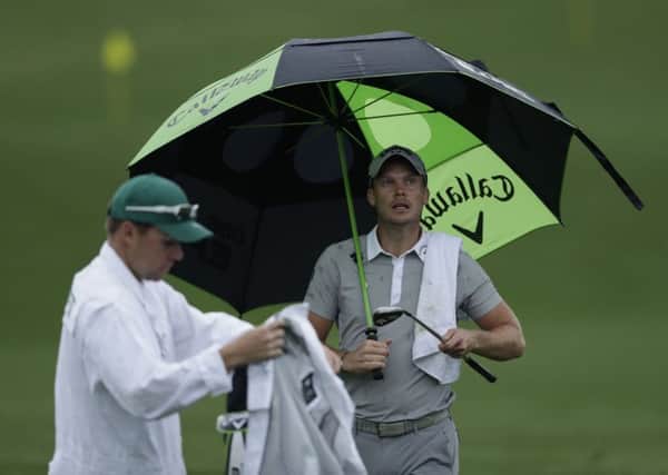 Masters champion Danny Willett shelters under an umbrella during yesterdays practice session at Augusta (Picture: Matt Slocum/AP).